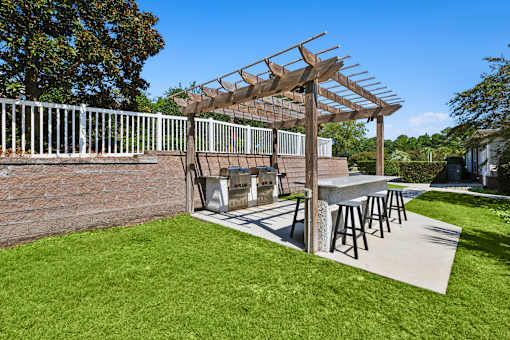 A patio with a white fence and a wooden pergola.