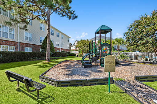 A playground with a slide and a sign that says rules.