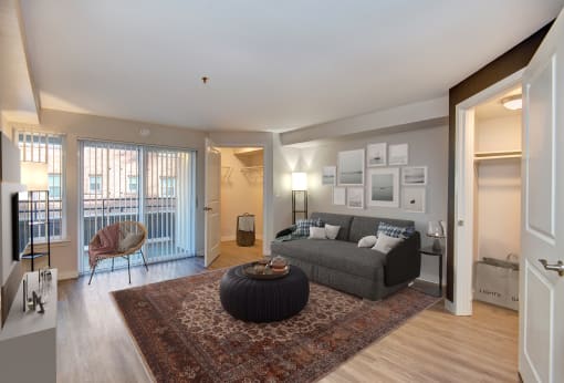Seattle, WA Luxury Apartments - Union Bay- Living Room with Grey Couch, Patio Entrance, and Circle Coffee Table
