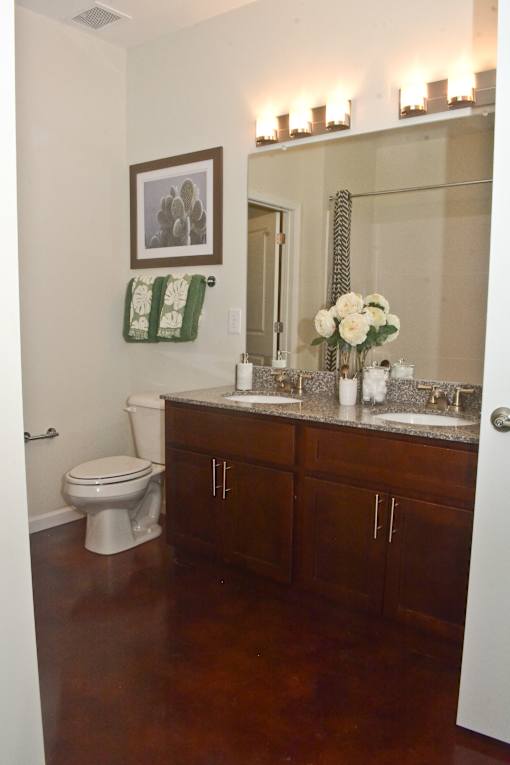 A bathroom with a toilet, sink, and a mirror.