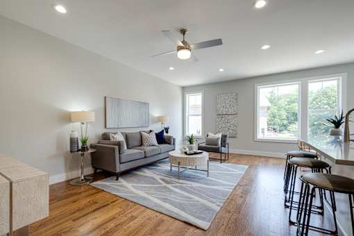 A living room with a grey couch, a white coffee table, and a rug.