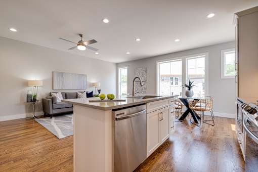 A kitchen with a dining table and chairs in the middle of the room.