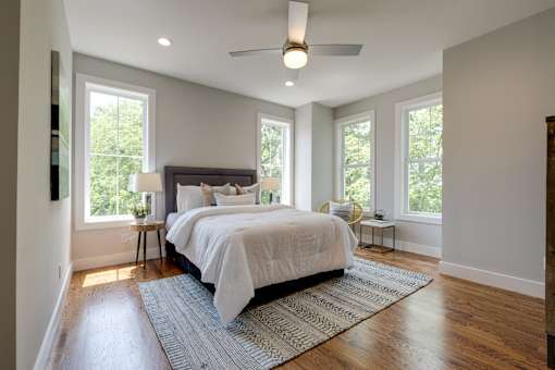 A bedroom with a large bed and a ceiling fan.