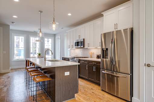 A modern kitchen with a large island and stainless steel appliances.