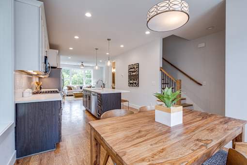 A kitchen with a wooden table and a plant on it.