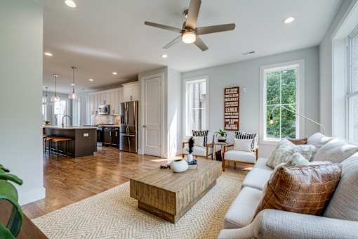 A modern living room with a white couch and a wooden coffee table.