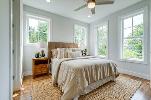 A bedroom with a large bed and a ceiling fan.