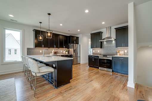 A modern kitchen with dark wood cabinets and a large island.