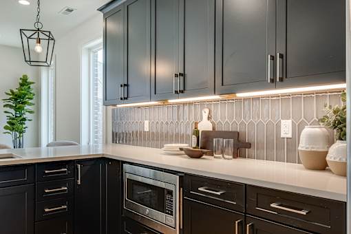 A kitchen with black cabinets and a white countertop.