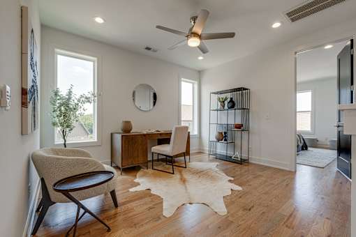 A room with a chair, desk, and a mirror on the wall.