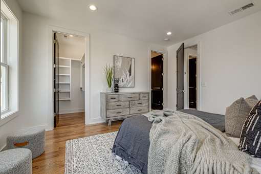 A bedroom with a bed, dresser, and chair.