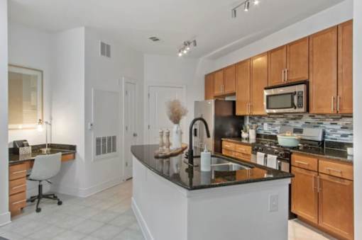 A kitchen with a black countertop and wooden cabinets.