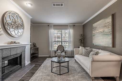 A living room with a fireplace, a couch, and a painting on the wall.