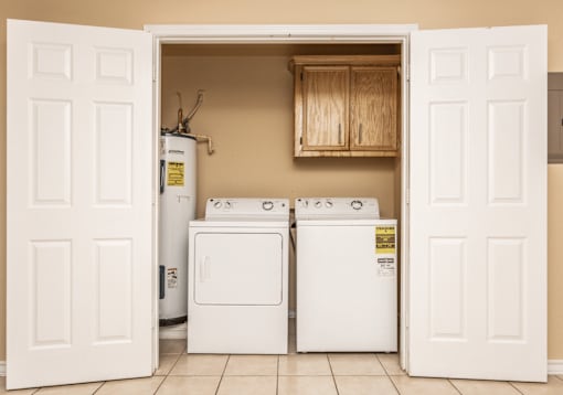 A white door is open to a laundry room with a washer and dryer.