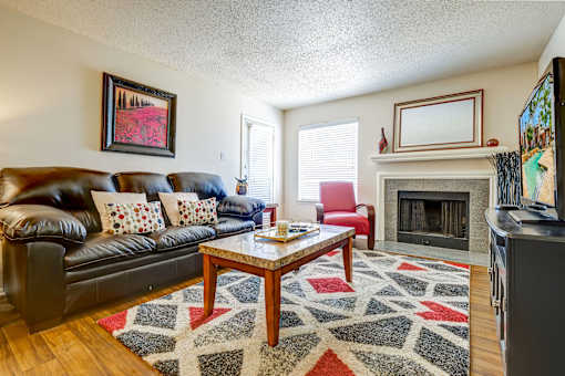 A living room with a red couch and a ceiling fan.