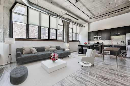 A modern living room with a grey couch and a white coffee table.