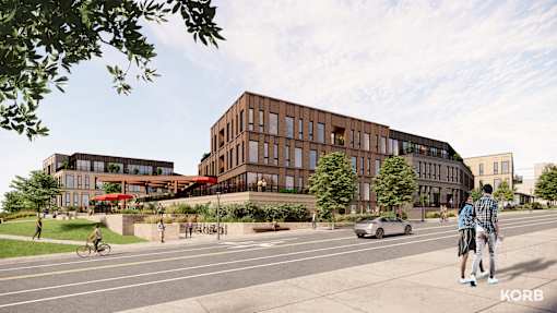 A street view of a modern building with people walking and riding bikes.