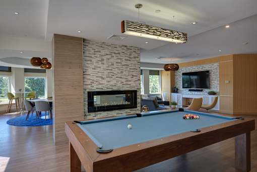 A pool table in a room with a stone fireplace.