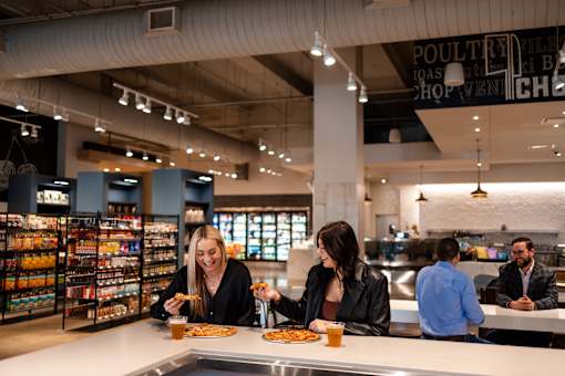 Two women are sitting at a counter in a poultry shop.