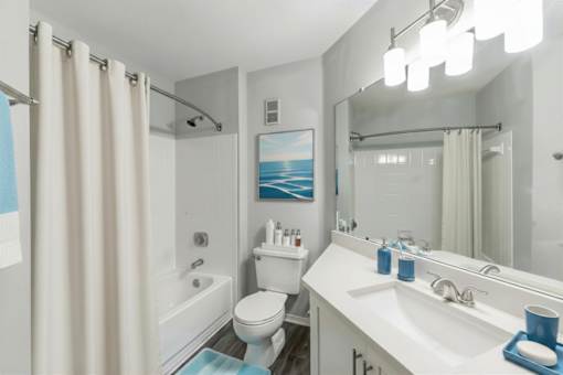 A bathroom with a toilet, sink, and shower.