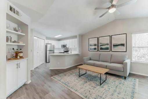 A modern kitchen with a refrigerator, a stove, and a dining table.