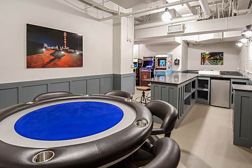 A blue table is in the middle of a room with a black leather chair.