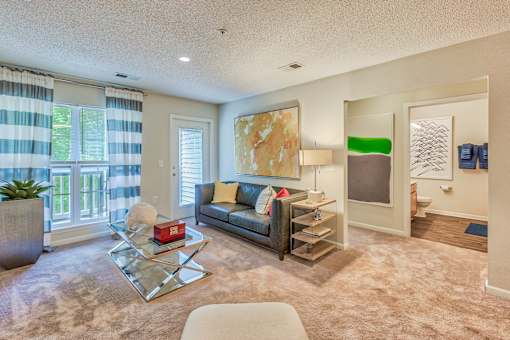 A living room with a couch, coffee table, and a painting on the wall.