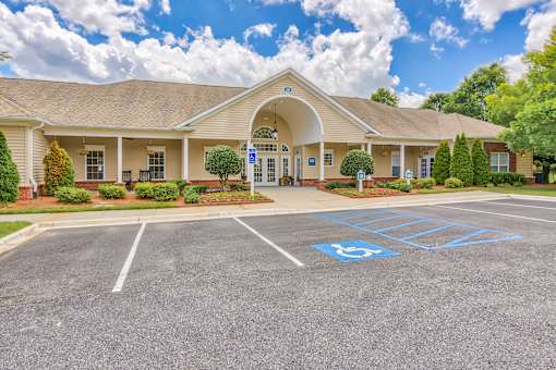 A parking lot in front of a building with a handicap parking space.