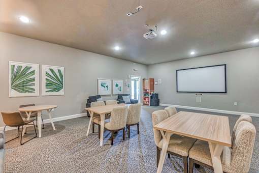 A room with a table and chairs and a painting on the wall.