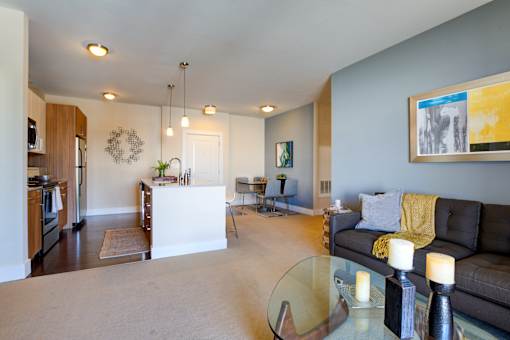 A living room with a couch, a coffee table, and a painting on the wall.