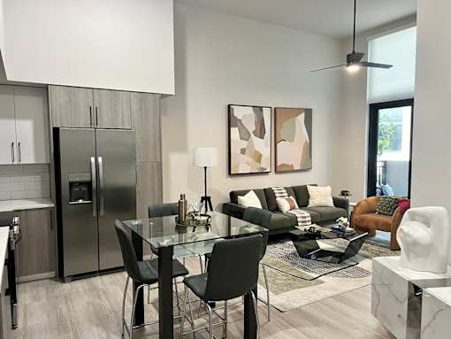A modern kitchen with a glass dining table and chairs.