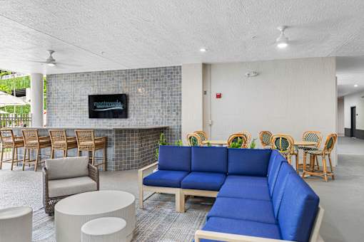 A blue sofa sits in the middle of a room with a fireplace and chairs.