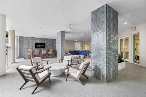 A living room with a white couch and a blue chair.