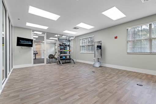 A room with a wooden floor and a mounted speaker on the wall.