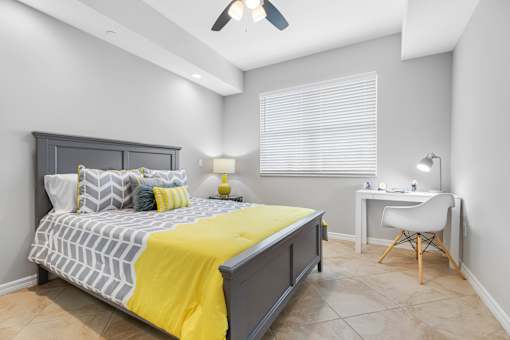 A bedroom with a bed, desk, and chair.