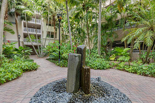 A stone monument sits in the middle of a garden.