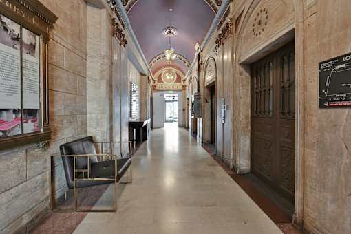 A long hallway with a bench and a door at the end.