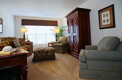 A living room with a brown cabinet and a grey couch.