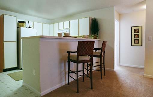 A kitchen with a table and chairs.