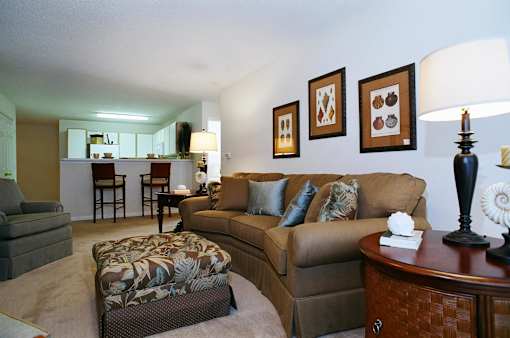 A living room with a brown couch and a lamp.