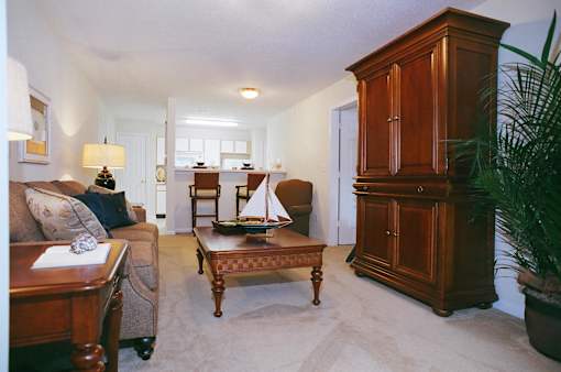 A living room with a couch, coffee table, and a cabinet.