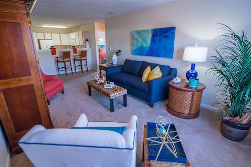 A living room with a white couch and a blue couch.