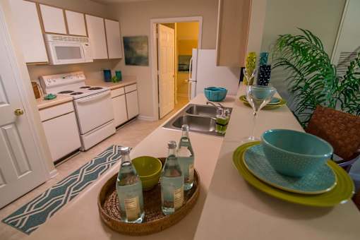 A kitchen with white appliances and a green bowl on a green plate.