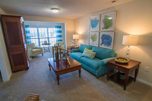 A living room with a blue couch and a wooden coffee table.