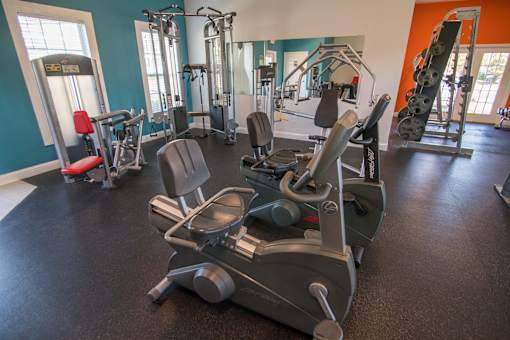 A gym with a rowing machine in the foreground.