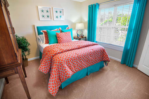 A bed with a red and white comforter is in the center of the image.