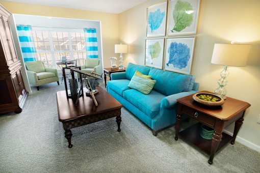 A living room with a blue couch and a brown coffee table.