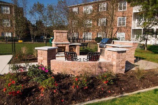 A brick wall with a bench and a table in front of a building.