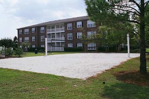A large brown building with a white sign in front of it.