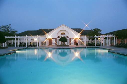 A large house with a pool in front of it.